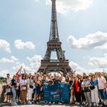 An image for the WowTrip Tours case study, showcasing tourists in Paris proudly holding the WowTrip Tours flag.